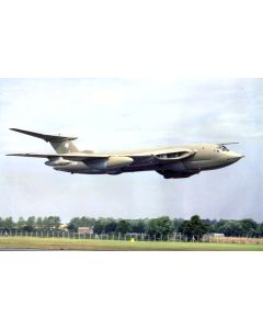 A vintage military aircraft flying above a landscape, showcasing its distinctive design and sleek profile against a cloudy sky.