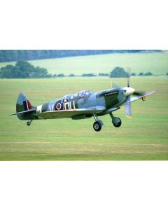 Vintage Supermarine Spitfire aircraft flying low over a green landscape.
