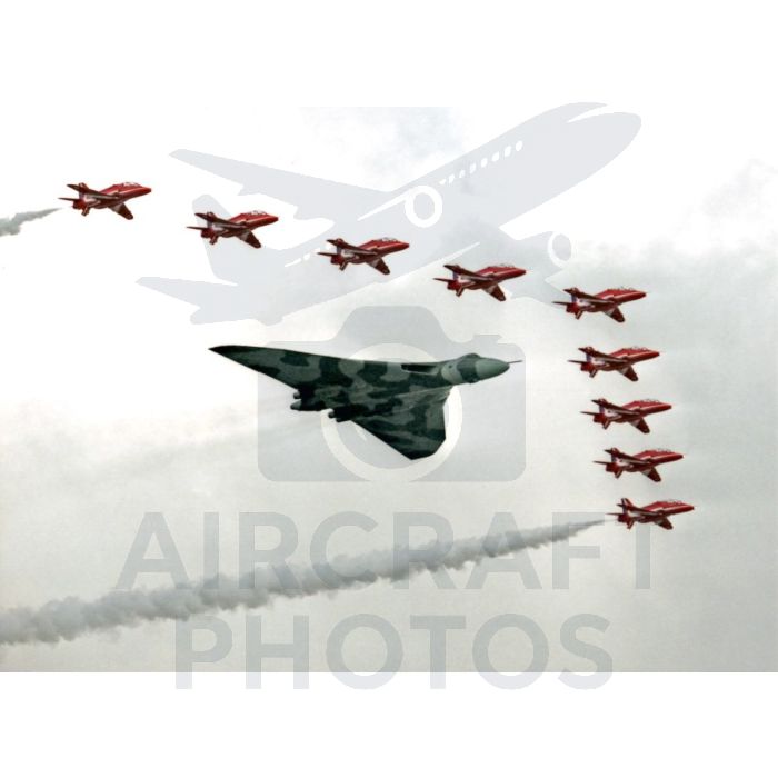 A striking aerial display featuring a vintage bomber aircraft leading a formation of red fighter jets, leaving colorful smoke trails against a cloudy sky.