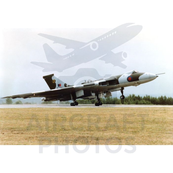 Vulcan bomber taking off on a runway with green trees in the background.