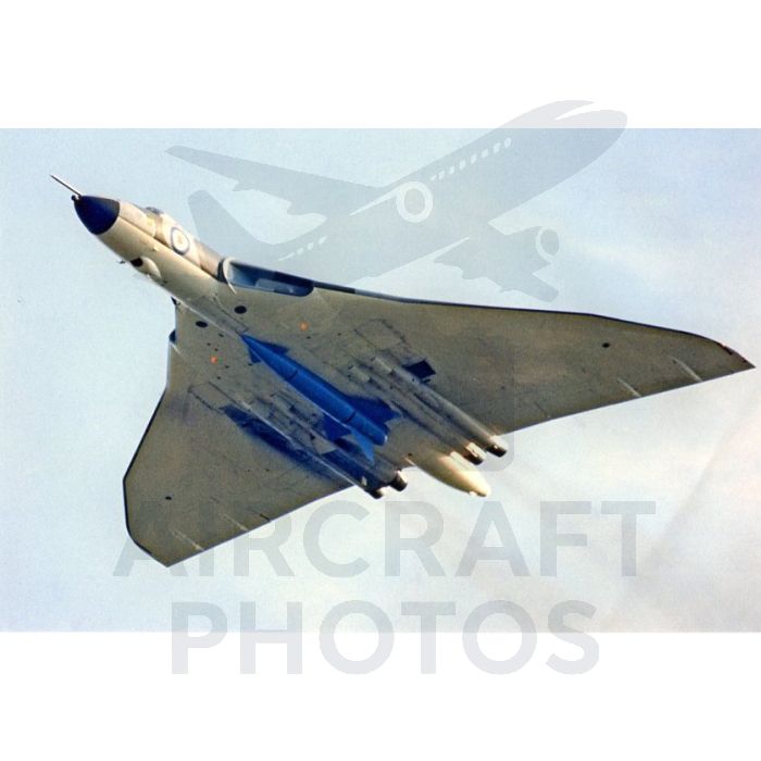 A sleek, delta-wing jet aircraft with blue accents is captured in flight against a cloudy sky, showcasing its unique aerodynamic design and military features.